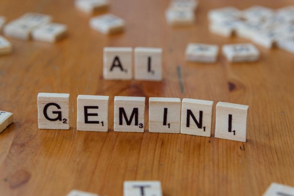 Wooden tiles spelling out "AI GEMINI" on a natural wooden surface representing the brand.