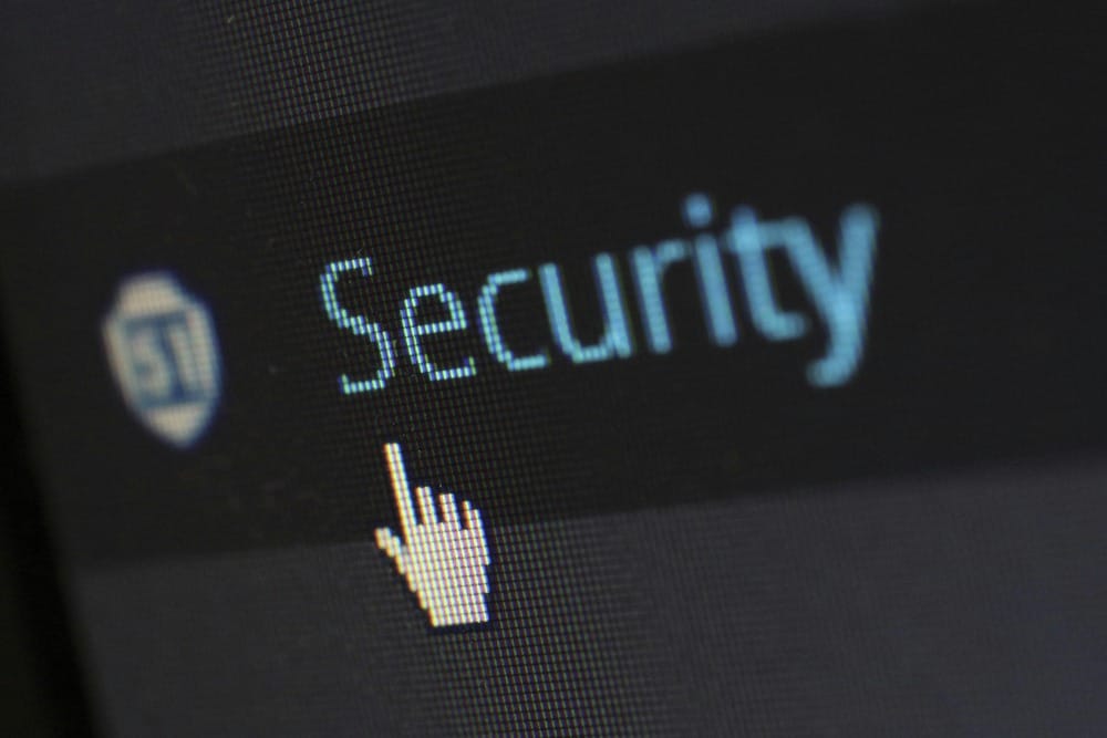 Close up of a digital screen showing a security shield icon and cursor representing online protection.